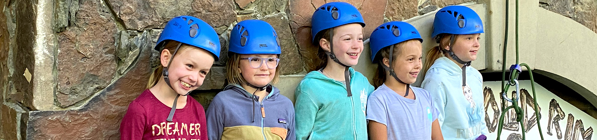  group of girl scouts with climbing helmets at camp 