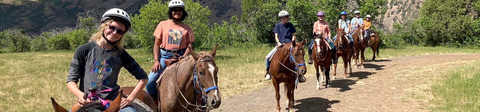  adult and girl scouts on a horseback trail ride 