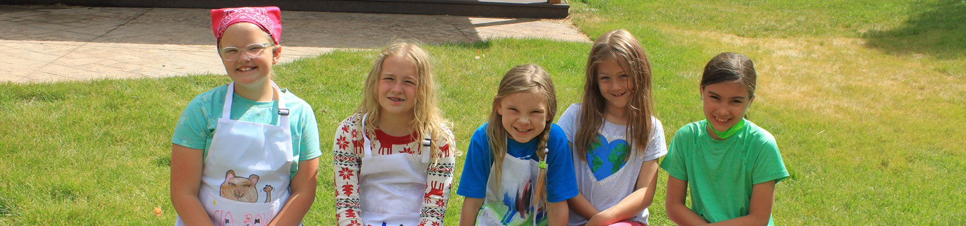  group of girl scouts with aprons for cooking program at camp 